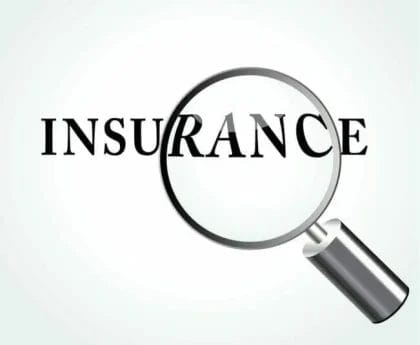 A magnifying glass focusing on the word "INSURANCE" on a light background.